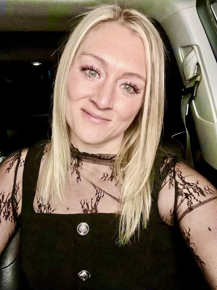 Taylor smiling in a black lace top